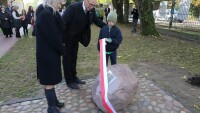 Tomasz Maliszewski z wnukiem odsłania pamiątkową tabliczkę